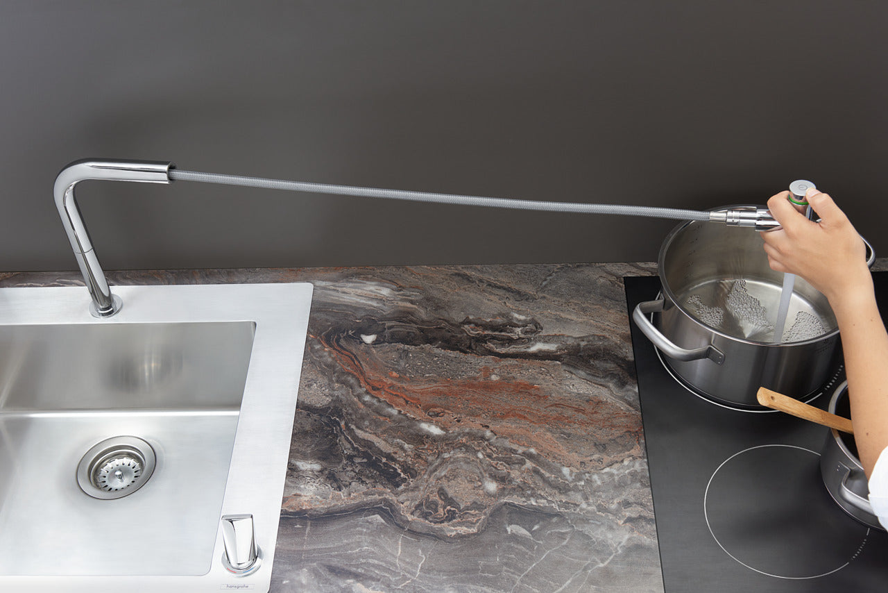 woman filling kitchen pot with hansgrohe kitchen sink mixer with pull out spray